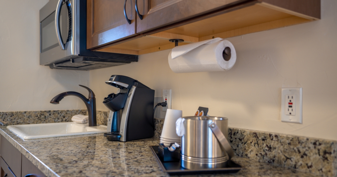 Marble kitchen countertop with a coffee machine, ice bucket and disposable glasses