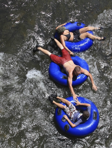 Three people floating on inflatable rings in the water