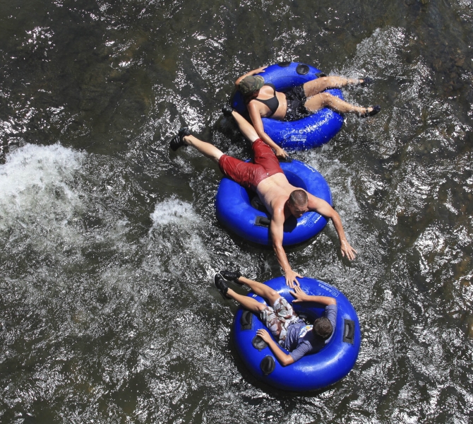 Three people floating on inflatable rings in the water